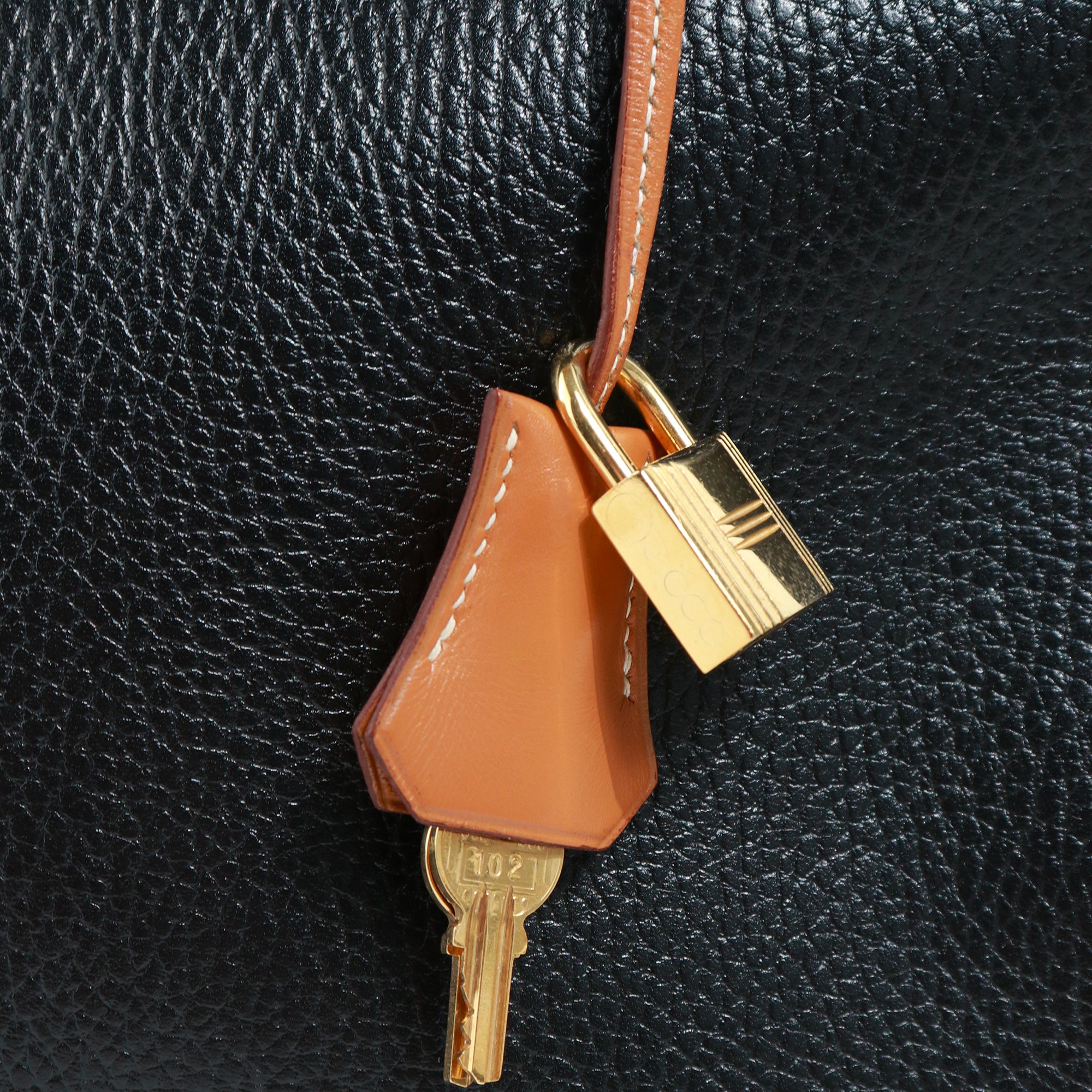 HERMÈS - Sac à main Kelly 35 en cuir togo bicolore noir et gold