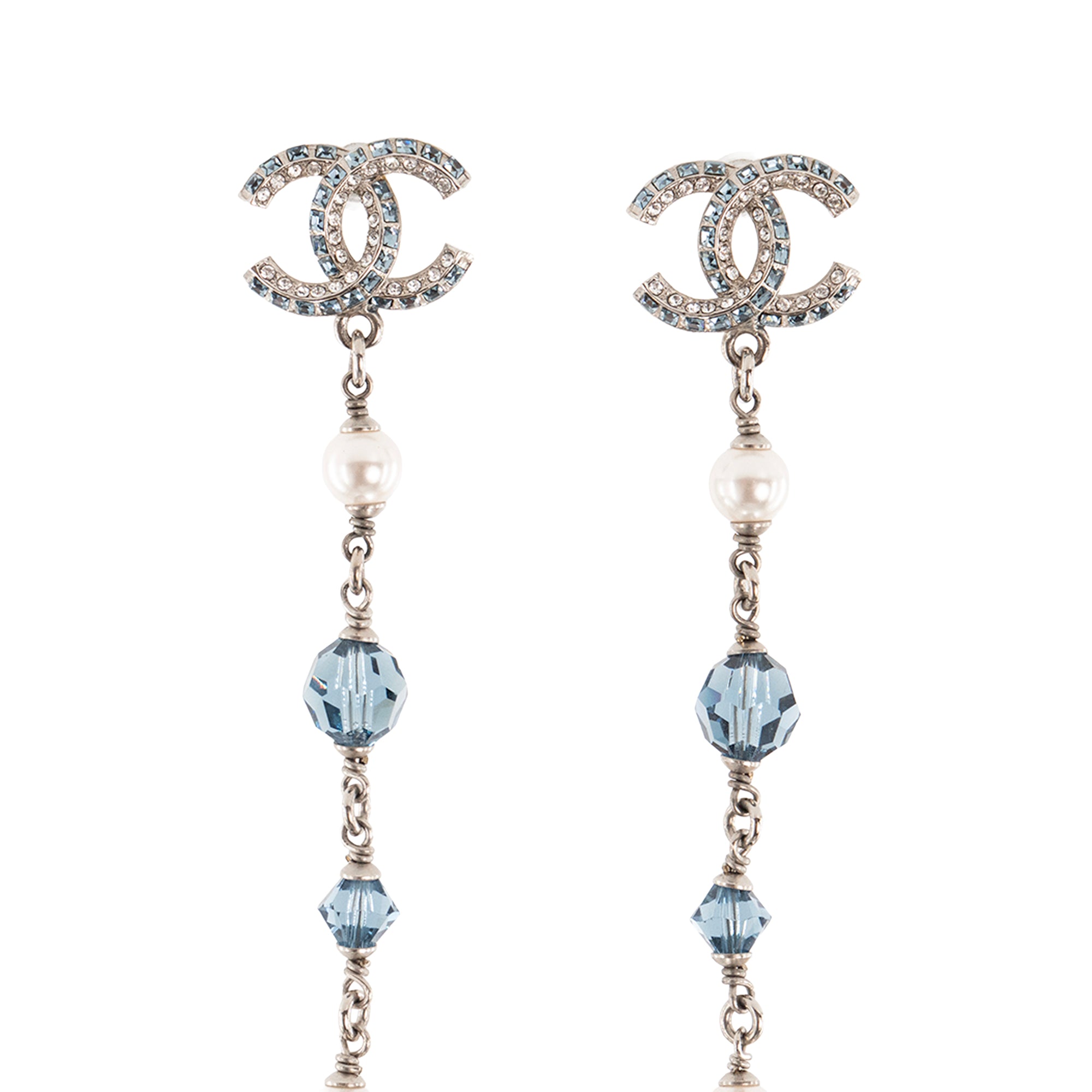 CHANEL - Boucles d'oreilles pendantes Chanel en métal argenté et cristal bleu